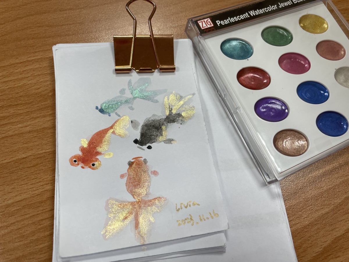 栗子的作畫桌：珠光顏料盒與畫到一半的金魚